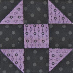 May include: A quilt block with a purple and black geometric pattern. The block is made up of four squares, each with a different pattern. The squares are arranged in a checkerboard pattern.