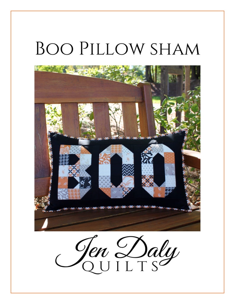 May include: A black pillow sham with a patchwork "BOO" design in orange, white, and black fabrics. The pillow is sitting on a wooden bench outdoors.