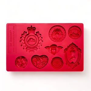 May include: A red silicone mold with various embossed designs, including a lion's head, a heart, and a framed portrait. The mold also features text that reads "Get Inspired" and "www.dadarkartz.com".