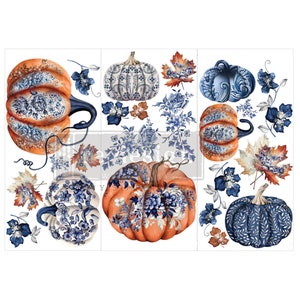 May include: A sheet of decorative transfers featuring orange pumpkins with blue and white floral patterns. The sheet also includes blue floral sprigs and fall leaves in shades of orange and brown. The design has a vintage, farmhouse aesthetic.