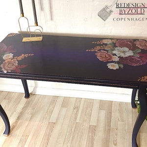 A vintage table refurbished by Redesign by Zold Copenhagen is painted midnight blue and features the Floral Romance transfer on the top.