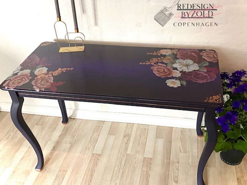 A vintage table refurbished by Redesign by Zold Copenhagen is painted midnight blue and features the Floral Romance transfer on the top.