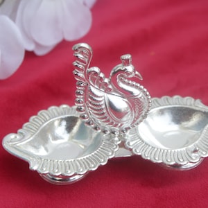 peacock with 2 side diya,  peacock with 4 haladi kumkum holder german silver return gifts, wedding favo golu pooja favors, varalakshmi gifts