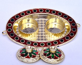 May include: An oval tray with a red and green border, made of gold-coloured metal. The tray has two small, round, gold-coloured bowls. Two matching gold-coloured lids with red and green designs are next to the tray.