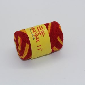May include: A roll of red and yellow thread with a yellow label that reads "Telisar II™ Kalava".