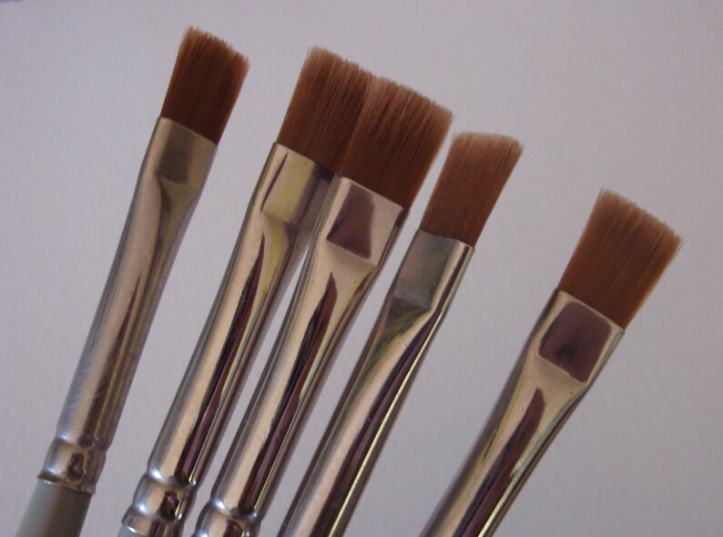 May include: Five flat paint brushes with silver metal handles and brown bristles.