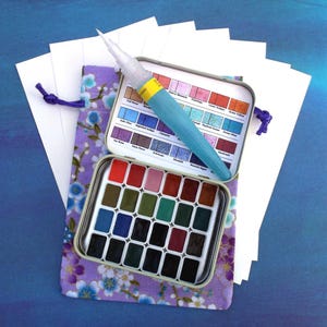 HOLBEIN Japan 2025 New Colors of All Granulating Watercolors with 24 Nature Themed Mini Pans, Mint Tin, Pouch, Water Brush, Postcards Set