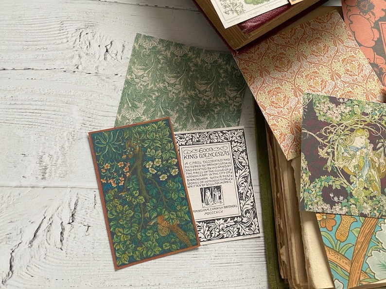 May include: A collection of vintage-style cards and book pages with botanical and floral designs. The cards feature detailed illustrations in shades of green, brown, and orange. Some cards have text, and the overall aesthetic is reminiscent of antique ephemera.