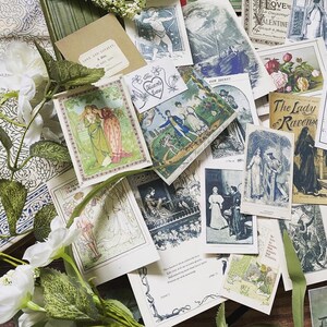 May include: A collection of vintage-style postcards and ephemera, featuring illustrations and text. The cards are scattered among white floral accents and a patterned book. The color palette includes greens, blues, and creams.