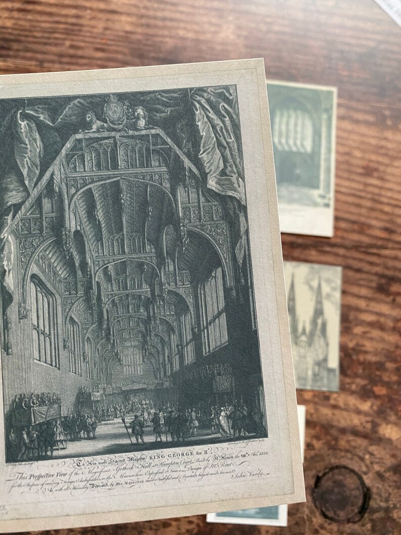 K&ouml;nnte beinhalten: Ein Schwarz-Wei&szlig;-Druck eines gro&szlig;en Saals mit gew&ouml;lbten Decken, detaillierten Fenstern und Figuren. Der Druck enth&auml;lt Text am unteren Rand mit den Worten "KING GEORGE the II". Weitere Drucke sind im Hintergrund sichtbar.