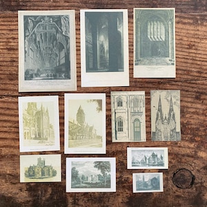 K&ouml;nnte beinhalten: Eine Sammlung von Vintage-Architektur-Drucken, die detaillierte Illustrationen von Kathedralen, Kirchen und anderen historischen Geb&auml;uden zeigen. Die Drucke sind in Grau- und Gr&uuml;nt&ouml;nen gehalten und auf einer rustikalen Holzoberfl&auml;che angeordnet.