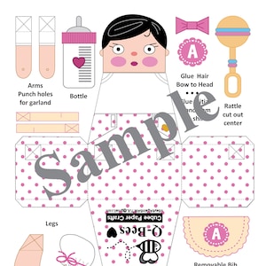 May include: A printable baby-themed paper craft template with a doll-like figure, bottle, rattle, and bib. The design features pink polka dots and the text "Sample" and "Q-Bees". Includes instructions for assembly and the text "No. 5C_ASIAN".