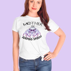 May include: White t-shirt with a graphic of a jumping spider and the text "Mother of Jumping Spiders".
