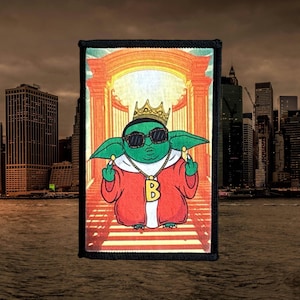 May include: A green cartoon character wearing a gold crown, sunglasses, and a red jacket with a gold chain and a letter 'B' pendant. The character is standing in a doorway with a yellow and orange background.