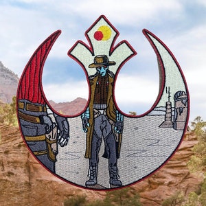May include: Embroidered patch featuring a stylized character in a brown coat and hat, set against a red and white emblem. The design includes a desert landscape and a figure with a blue face. The patch is bordered in red.