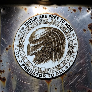 Pode incluir: Uma caneca de cerâmica branca com uma alça preta e o texto "But First, Coffee" em negrito preto. A caneca está sobre um fundo desfocado, destacando seu design limpo.