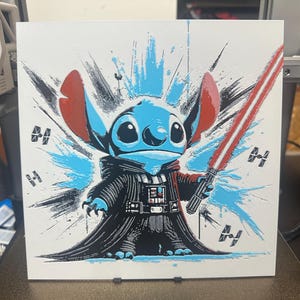 May include: A blue and red cartoon character with large ears and a black Darth Vader costume holding a red lightsaber. The character is surrounded by blue and white paint splatters and the background is white.