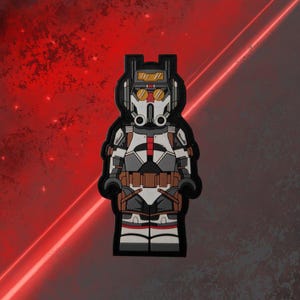 Może przedstawiać: Czarno-biała figurka akcji klona szturmowca z Gwiezdnych Wojen z czerwono-białym hełmem i brązowym pasem. Figurka ma na sobie biało-szary kombinezon z czarnym pancerzem i czarnym plecakiem.