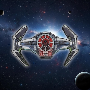 May include: Embroidered patch featuring a TIE fighter from a space opera franchise. The patch is primarily silver, with black and green accents. The cockpit features a red and black design. The background is a starry galaxy with planets.