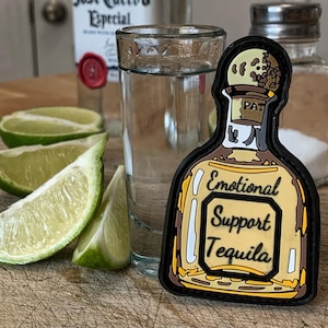 May include: A yellow and brown tequila bottle patch with the text "Emotional Support Tequila".