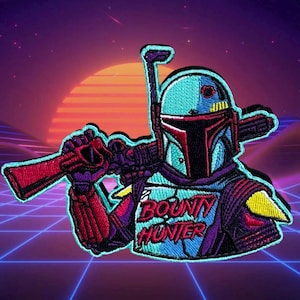 May include: A blue and purple embroidered patch featuring a stylized image of Boba Fett, a bounty hunter from the Star Wars universe. The patch has the text "BOUNTY HUNTER" on it.