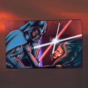 Può includere: Un'illustrazione in blu scuro e nero di Darth Vader che si confronta con una Jedi femminile con una spada laser blu. Lo sfondo è un motivo a griglia rosso e bianco.