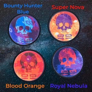 Pode incluir: Quatro bases redondas com desenhos de caveiras e o texto "22". As bases estão rotuladas como "Bounty Hunter Blue", "Super Nova", "Blood Orange" e "Royal Nebula". Cada base apresenta um esquema de cores diferente, incluindo azul, laranja e vermelho.