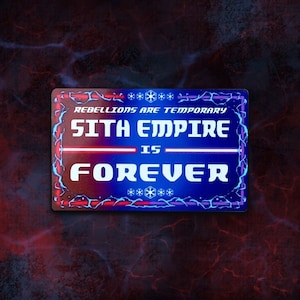 Pode incluir: Uma placa azul e vermelha com uma borda branca e texto branco que diz "As rebeliões são temporárias, o Império Sith é para sempre". A placa tem um símbolo de Star Wars nos cantos superior e inferior.