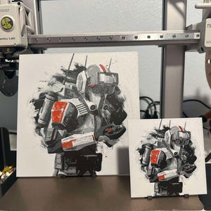 May include: Two framed prints of a black and white illustration of a futuristic soldier wearing a white helmet with red accents. The soldier is holding a weapon in their right hand. The background is a gray and white abstract design.
