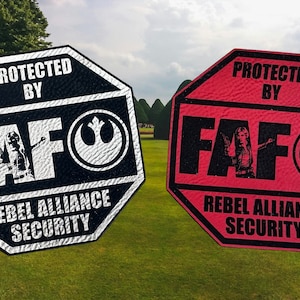 May include: Two octagonal signs with the text "Protected by FAF Rebel Alliance Security" in black and white on a black background and in black on a red background. The signs feature a Rebel Alliance symbol and a silhouette of Princess Leia.