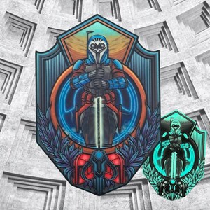 May include: A blue and orange illustrated sticker of a Mandalorian warrior holding a lightsaber. The sticker has a glow-in-the-dark effect.