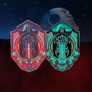 Könnte beinhalten: Zwei im Dunkeln leuchtende Emaille-Pins mit Darth Vader aus Star Wars. Die Pins haben die Form eines Schildes mit rotem und grünem Leuchten. Die Pins sind von Rosen umgeben.