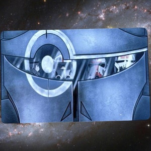 May include: A close-up of a blue and gray helmet with a circular design on the front. The helmet has a visor that is partially open, revealing the faces of several people inside.