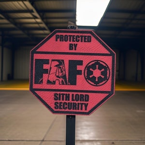 May include: A red octagonal sign with the text "Protected by FAF" and a Star Wars symbol. The sign also says "Sith Lord Security".