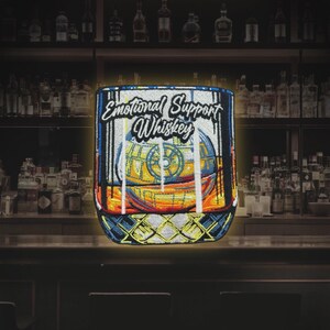 May include: A blue and yellow embroidered patch of a glass of whiskey with the text "Emotional Support Whiskey" and a Death Star inside the glass.