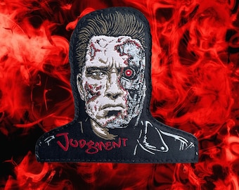 May include: Embroidered patch featuring a black and white image of the Terminator with a red eye. The patch has a black background with the word "Judgment" written in red.