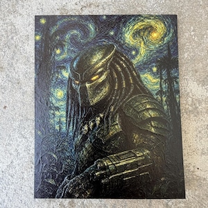 May include: A rectangular art print featuring a dark, armored extraterrestrial creature with glowing yellow eyes and dreadlocks. The figure is set against a swirling, textured night sky background with yellow stars and dark silhouettes of trees.