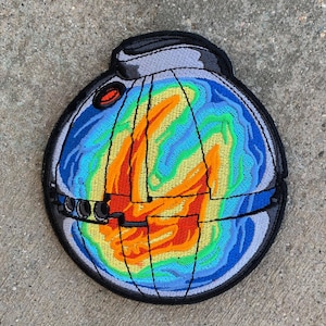 May include: A colourful embroidered patch of a Death Star from Star Wars. The patch is round and has a black outline. The Death Star is depicted in a rainbow colour scheme with a red centre.