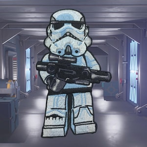 Könnte beinhalten: Ein gestickter Aufnäher eines Lego Star Wars Stormtroopers, der ein Blastergewehr hält, in Blau und Weiß.