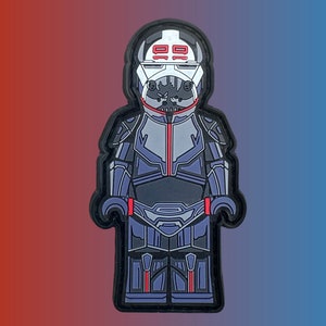 May include: A black and gray Lego minifigure wearing a white helmet with red accents and the number 99 on the front. The minifigure is wearing a black and gray suit with red accents.