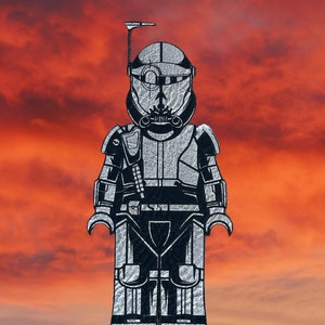 May include: A black and white illustration of a Star Wars clone trooper wearing a helmet and armor. The background is a sunset sky.