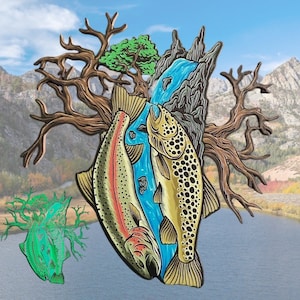 Op de afbeelding: Een kleurrijke emaille pin met twee forellen die in een beek zwemmen, omringd door een tak en een waterval. De pin is een levendige mix van groen, blauw, bruin en goud.