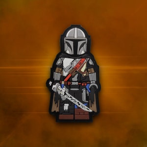 May include: A black, grey and brown Mandalorian character figurine with a silver helmet and a blue lightsaber. The figurine is wearing a black cape and has a red and white belt.