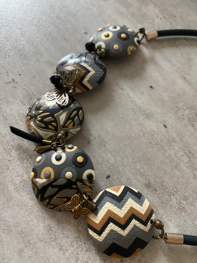 camel and gold polymer clay with metal charms and Swaro pearl. Short necklace in anthracite ecru