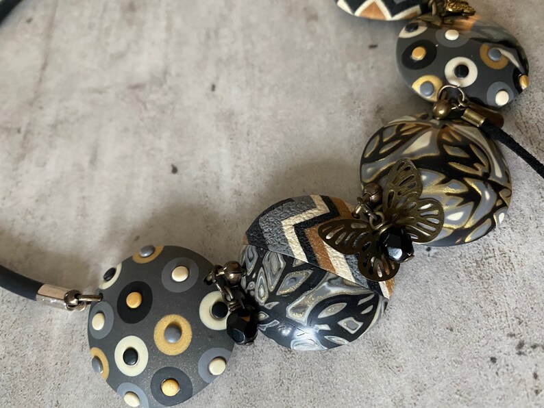 camel and gold polymer clay with metal charms and Swaro pearl. Short necklace in anthracite ecru