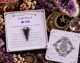 Puede incluir: Un péndulo de cristal de amatista morado facetado en una cadena plateada, presentado en una caja blanca con texto que describe sus propiedades. Al lado hay una tarjeta cuadrada blanca con una ilustración de mano hamsa negra y las palabras Yes, No, Maybe, Rephrase.