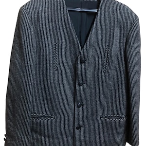 May include: A dark gray and brown striped blazer with a V-neck and four black buttons. The blazer has two front pockets and decorative stitching details. It is hanging on a black hanger.