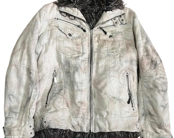 May include: A distressed off-white jacket featuring a dark brown faux fur collar and hem. The garment includes a central zipper, two chest pockets with snap buttons, two zippered side pockets, and decorative metal studs at the cuffs and hem.