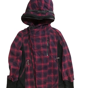 Puede incluir: Chaqueta con capucha a cuadros rojos y negros con paneles laterales, puños y cierre de cremallera negros. La capucha tiene un diseño único con un ribete negro. Prenda de vestir exterior elegante.