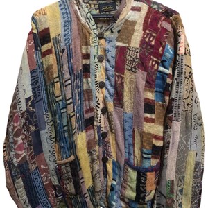 May include: A patchwork jacket with a variety of colors and patterns. The jacket has a mandarin collar, wooden buttons, and two front pockets. The jacket is hanging on a black hanger.